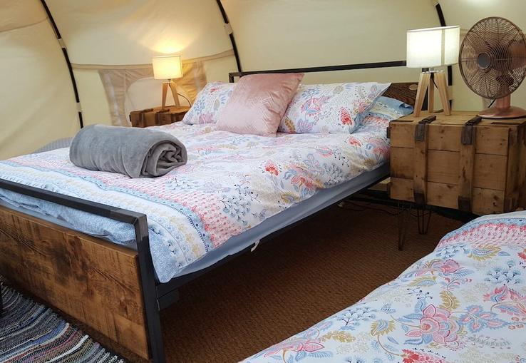Cosy bed in the belle tents at Campfires & Stars, a glamping site in the Cotswolds, Oxfordshire